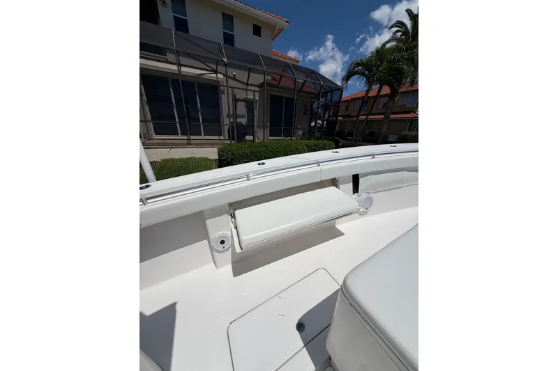 Slide: The Image of 2012 Invincible 42 Open Fisherman boat interior with white seating and coastal backdrop. - 30