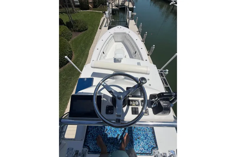 Slide: The Image of Helm view of 2012 Invincible 42 Open Fisherman boat docked by the water. - 39