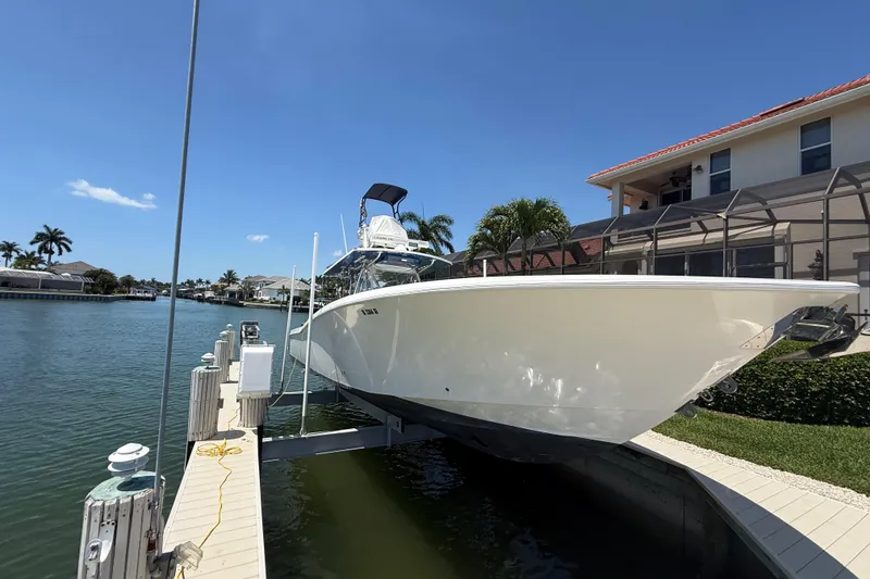 Slide: The Image of 2012 Invincible 42 Open Fisherman boat docked by waterfront home. - 4