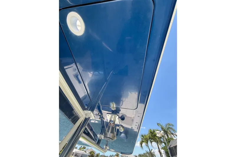 Slide: The Image of 2012 Invincible 42 Open Fisherman boat, blue hull, viewed from below, clear sky background. - 40