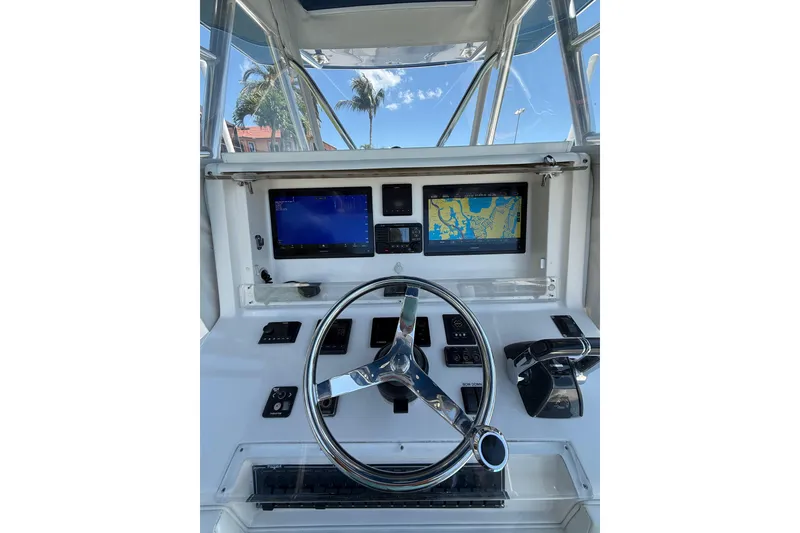 Slide: The Image of Helm of 2012 Invincible 42 Open Fisherman with navigation screens and steering wheel. - 5