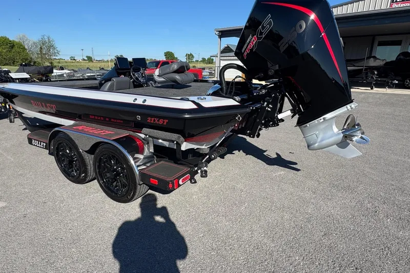 Slide: The Image of 2026 Bullet 21XST boat with powerful engine on trailer, parked outdoors. - 2