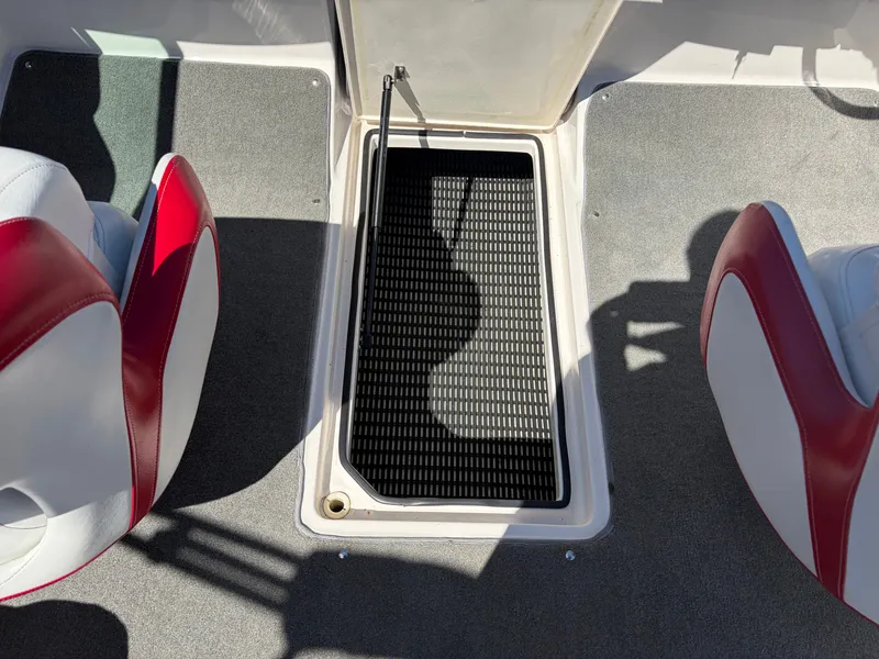 Slide: The Image of 2008 Regal 2200 Bowrider, open storage compartment between red seats. - 10