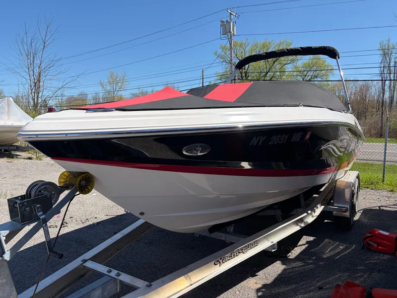 Slide: The Image of 2008 Regal 2200 Bowrider on trailer, black and red, parked outdoors. - 3