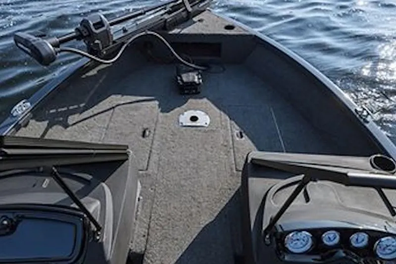 Slide: The Image of 2026 Crestliner 1750 Hawk WT boat interior with steering console on calm water. - 3