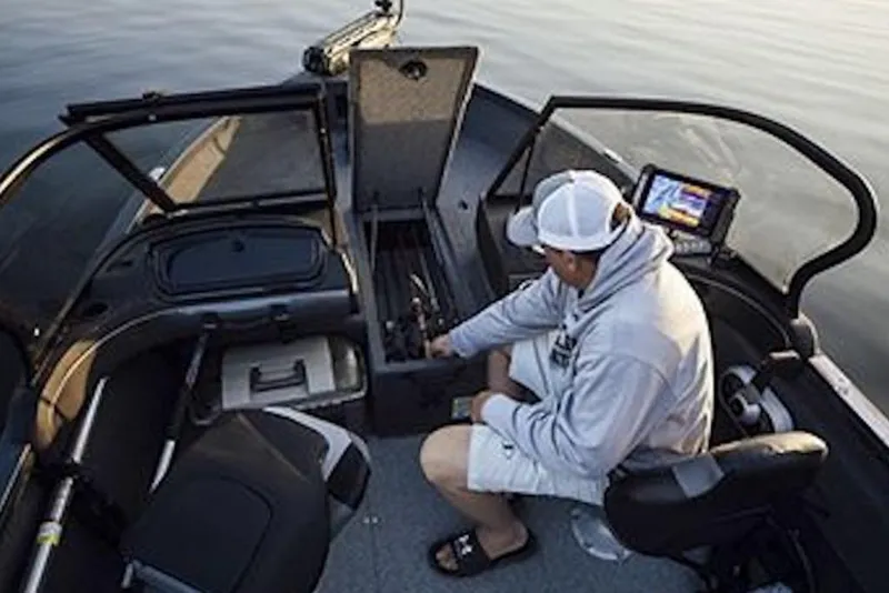Slide: The Image of Man organizing fishing gear on 2026 Crestliner 1750 Hawk WT boat interior. - 6