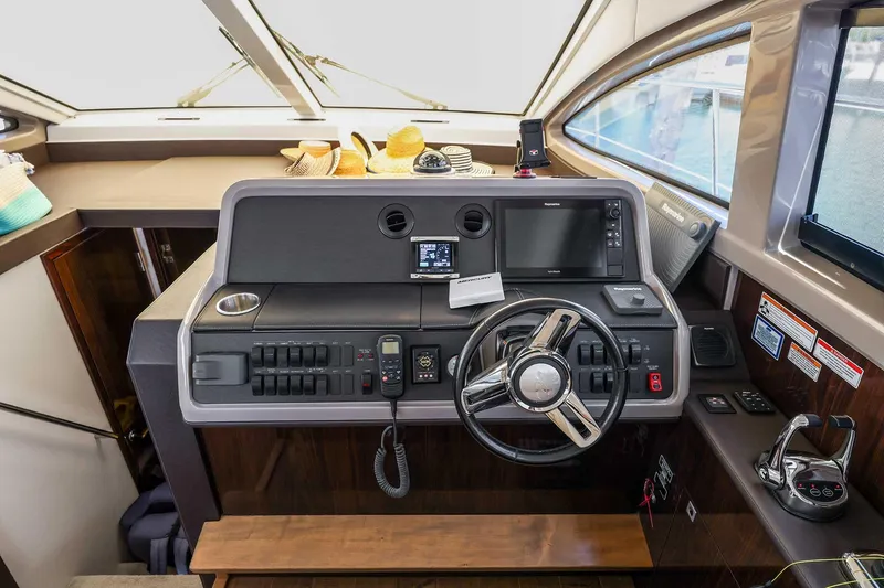 Slide: The Image of Cockpit of 2017 Sea Ray Sundancer 400 with modern navigation controls and steering wheel. - 13