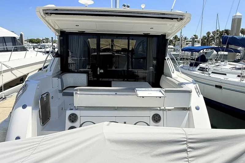 Slide: The Image of 2017 Sea Ray Sundancer 400 yacht docked at marina, rear view with seating area. - 6
