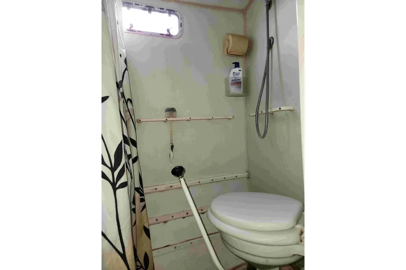 Slide: The Image of Compact marine bathroom with shower, toilet, and curtain in a 2000 Bruce Roberts boat. - 11