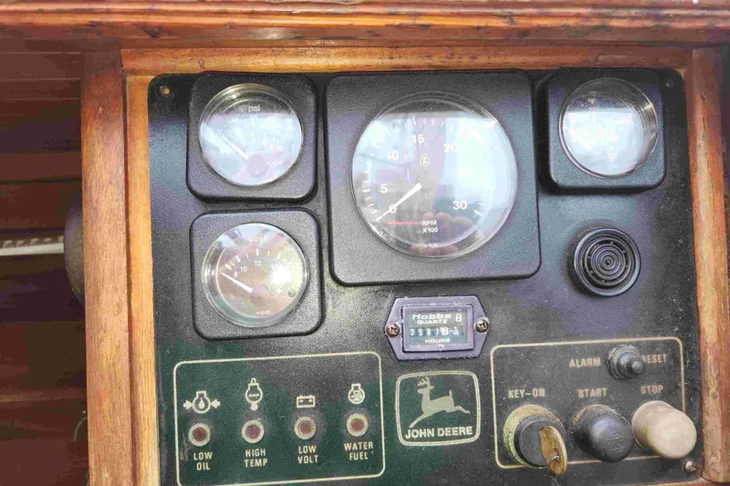 Slide: The Image of Control panel of a 2000 Custom Bruce Roberts boat with gauges and John Deere branding. - 23