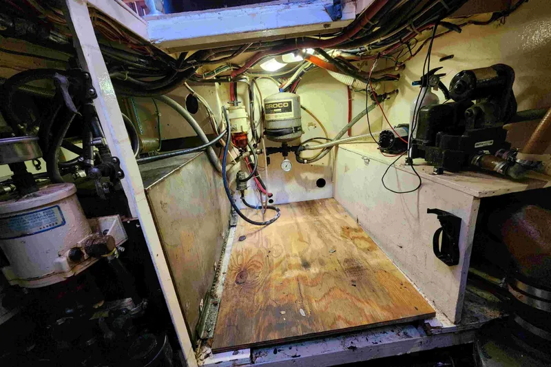 Slide: The Image of Engine room of a 2000 Custom Bruce Roberts boat, featuring mechanical equipment and wiring. - 26