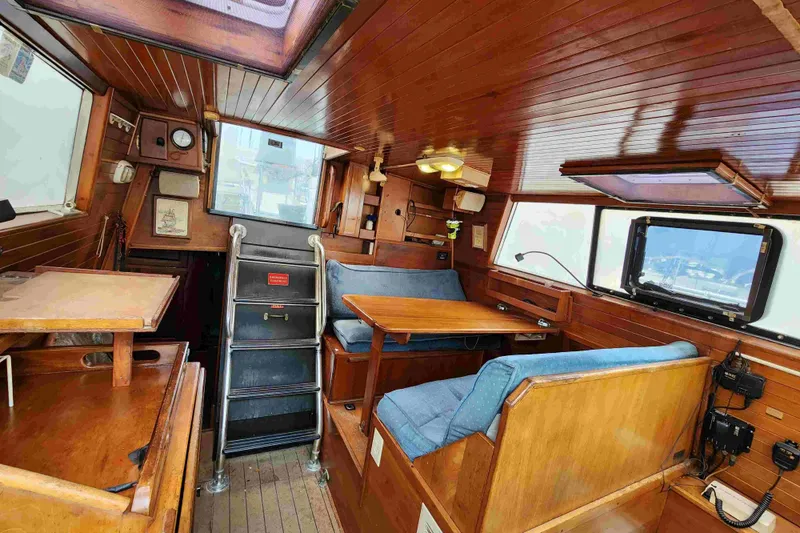Slide: The Image of Interior of 2000 Custom Bruce Roberts boat with wooden furnishings and blue seating. - 3