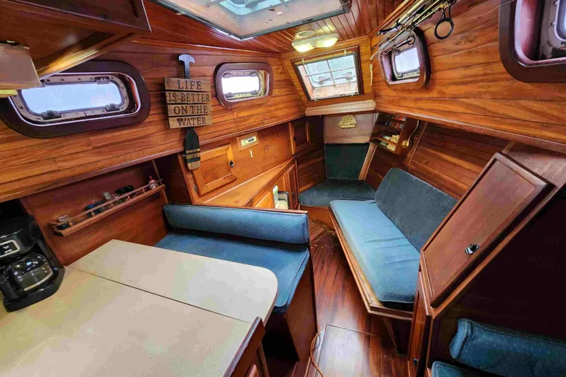 Slide: The Image of Cozy wooden interior of a 2000 Custom Bruce Roberts boat with seating and decor. - 7