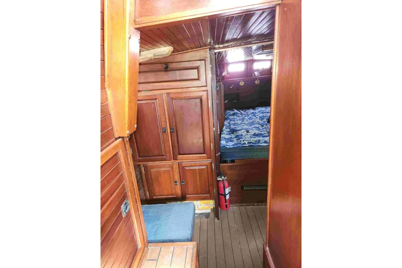 Slide: The Image of Wooden interior of a 2000 Custom Bruce Roberts boat, featuring cabinets and a cozy sleeping area. - 8