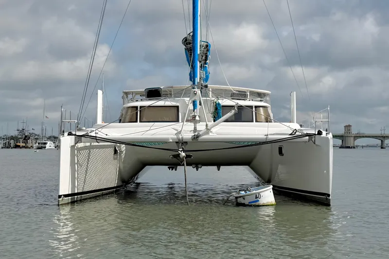 Slide: The Image of 2007 Dolphin 460 catamaran anchored in calm waters with cloudy sky backdrop. - 10