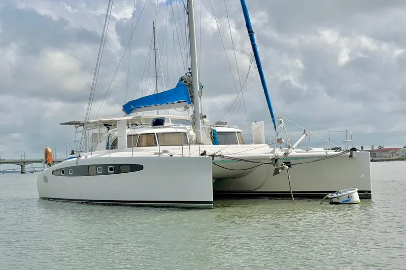 Slide: The Image of Catamaran Dolphin 460, 2007 model, anchored on calm waters under cloudy skies. - 11