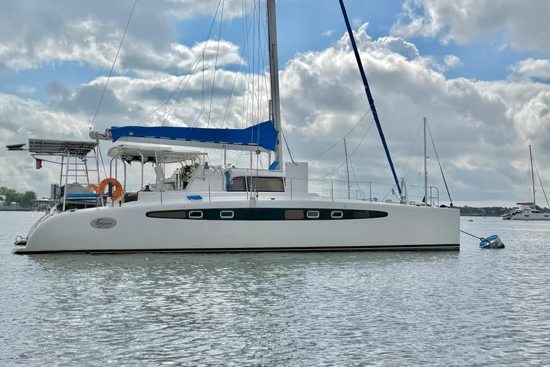 Slide: The Image of Sailing catamaran Dolphin 460, 2007 model, anchored on calm waters under a cloudy sky. - 12