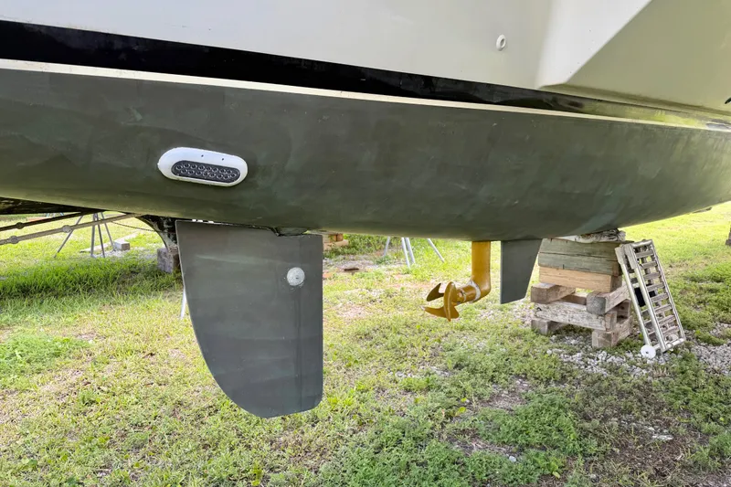 Slide: The Image of Bottom view of a 2007 Dolphin 460 boat on land, showing rudder and propeller. - 121