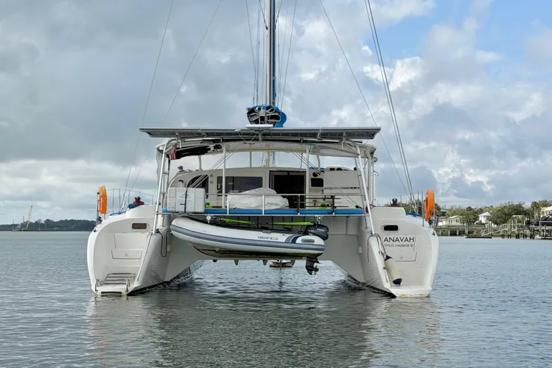 Slide: The Image of Catamaran Dolphin 460, 2007 model, anchored on calm waters under a cloudy sky. - 13