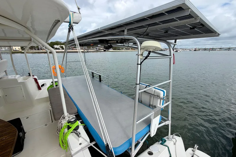 Slide: The Image of Catamaran Dolphin 460 (2007) with solar panels docked at marina, featuring spacious deck. - 14