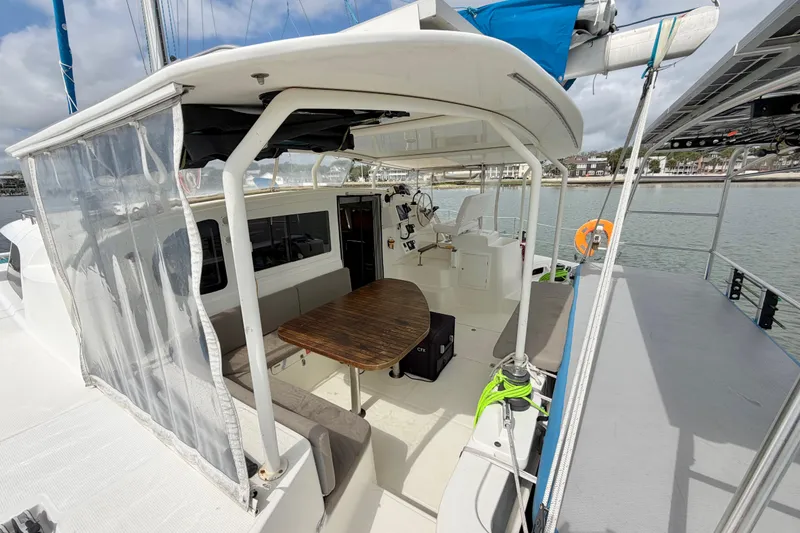 Slide: The Image of 2007 Dolphin 460 yacht cockpit with seating, table, and helm, docked by the water. - 18