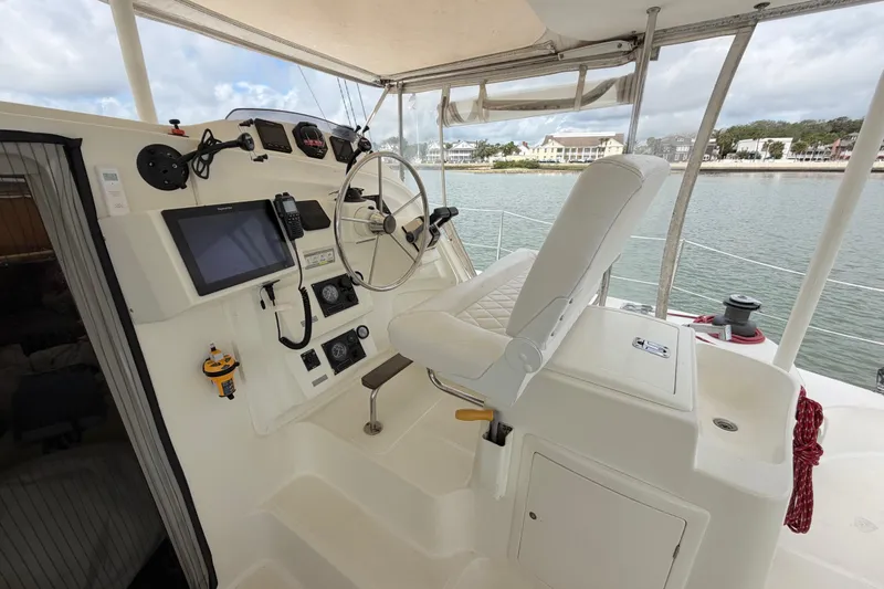 Slide: The Image of Helm of 2007 Dolphin 460 catamaran with steering wheel, navigation equipment, and comfortable seating. - 19