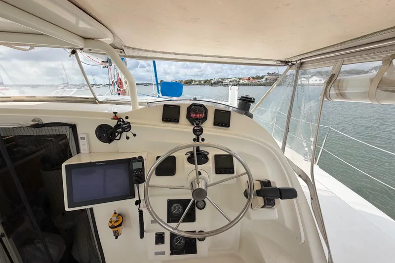 Slide: The Image of Helm of 2007 Dolphin 460 catamaran with navigation equipment, steering wheel, and ocean view. - 20