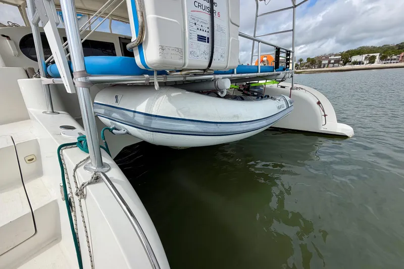 Slide: The Image of Inflatable boat secured on Dolphin 460 yacht, 2007 model, near a calm shoreline. - 26