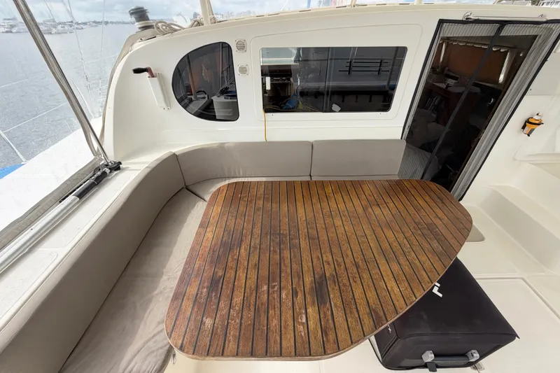 Slide: The Image of Cozy seating area on 2007 Dolphin 460 yacht with wooden table and window view. - 27