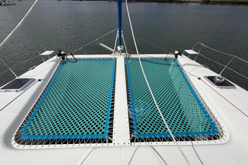 Slide: The Image of Catamaran Dolphin 460 (2007) with blue netting on deck, docked in calm waters. - 34