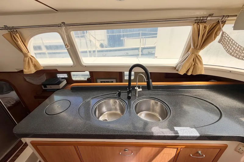 Slide: The Image of Modern kitchen area in a 2007 Dolphin 460 yacht with dual sinks and large windows. - 48