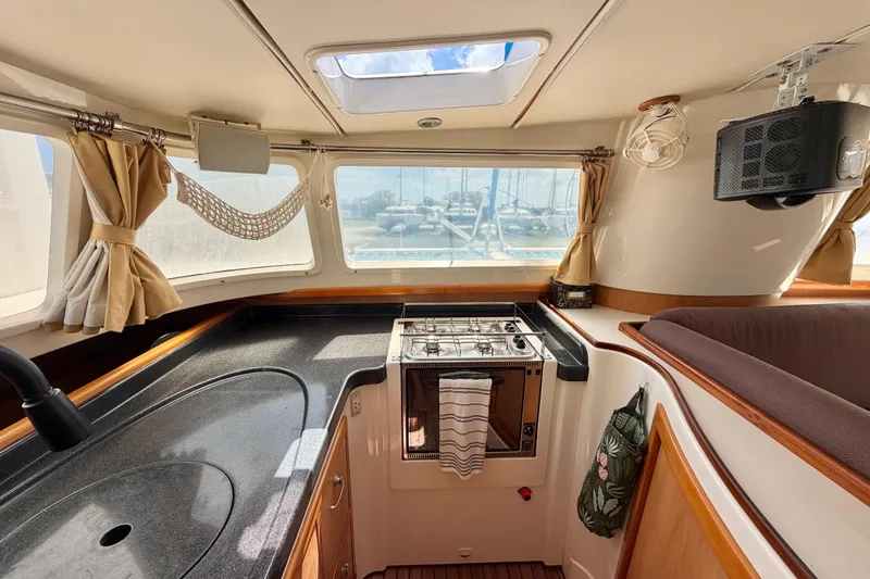 Slide: The Image of Interior of 2007 Dolphin 460 yacht kitchen with stove, sink, and windows. - 49