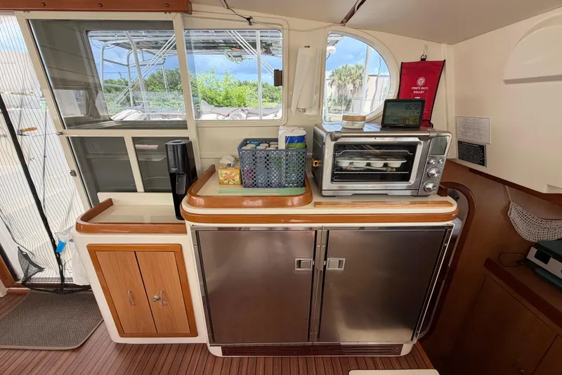 Slide: The Image of Interior of a 2007 Dolphin 460 yacht featuring a compact kitchen area. - 53
