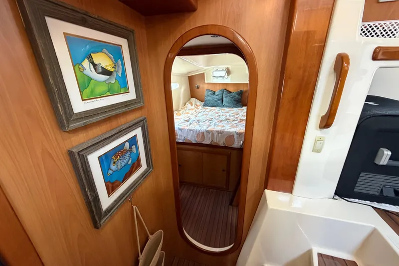 Slide: The Image of Interior of 2007 Dolphin 460 yacht with framed fish art and cozy bedroom. - 56