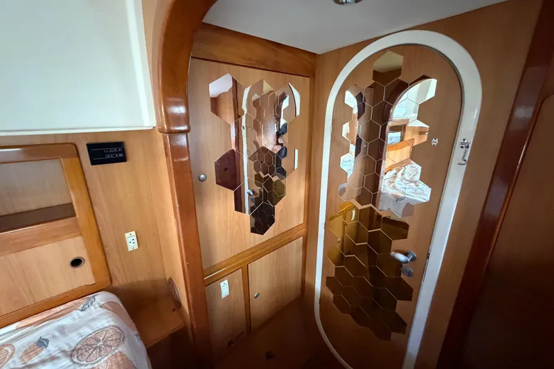 Slide: The Image of Interior of 2007 Dolphin 460 yacht with hexagonal mirror design on wooden door. - 60