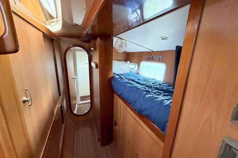 Slide: The Image of Cozy cabin interior of 2007 Dolphin 460 yacht with wooden finish and blue bedding. - 61
