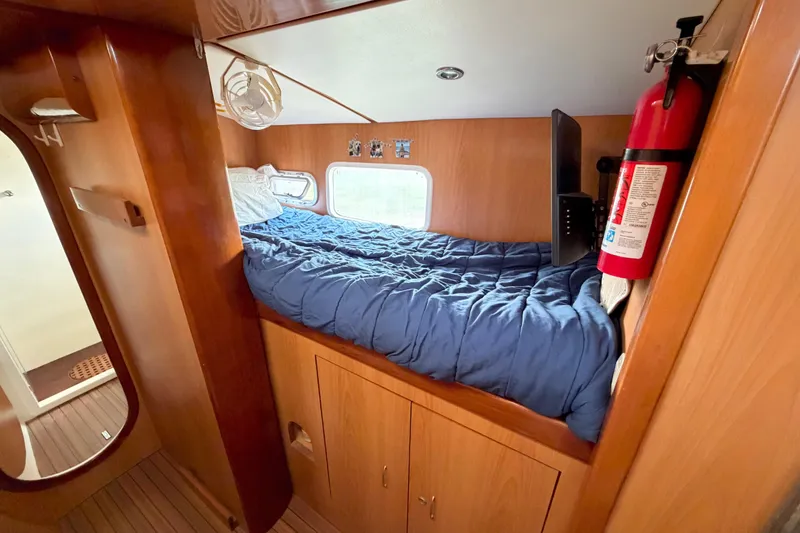 Slide: The Image of Cozy cabin interior of 2007 Dolphin 460 with bed, window, and fire extinguisher. - 62