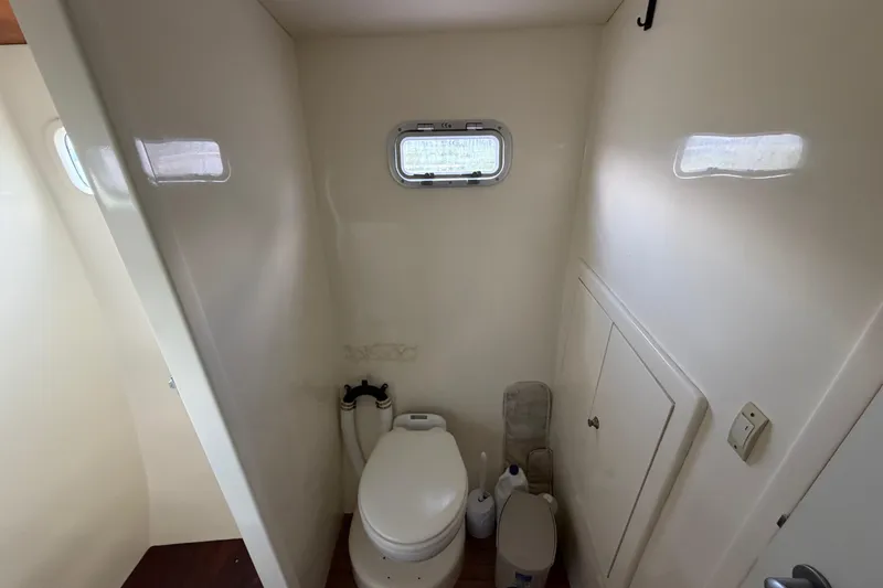 Slide: The Image of Compact bathroom in 2007 Dolphin 460 yacht with toilet and small window. - 66