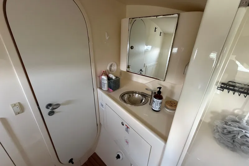 Slide: The Image of Compact bathroom in 2007 Dolphin 460 yacht with sink, mirror, and toiletries. - 68
