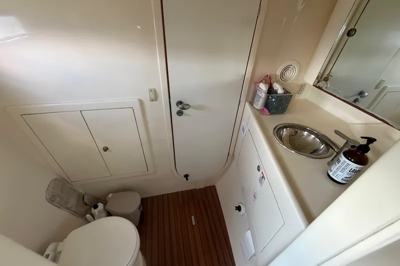 Slide: The Image of Compact bathroom in 2007 Dolphin 460 yacht with sink, toilet, and wooden floor. - 69