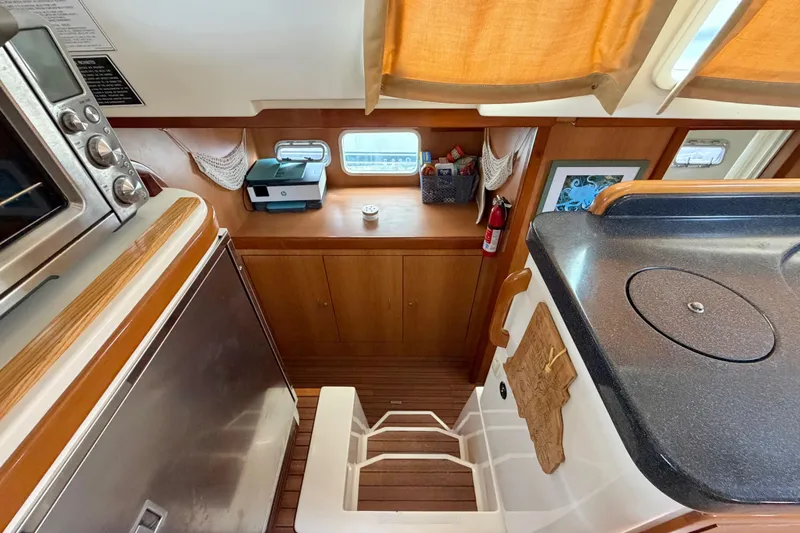 Slide: The Image of Interior of 2007 Dolphin 460 yacht kitchen with appliances and wooden cabinetry. - 72
