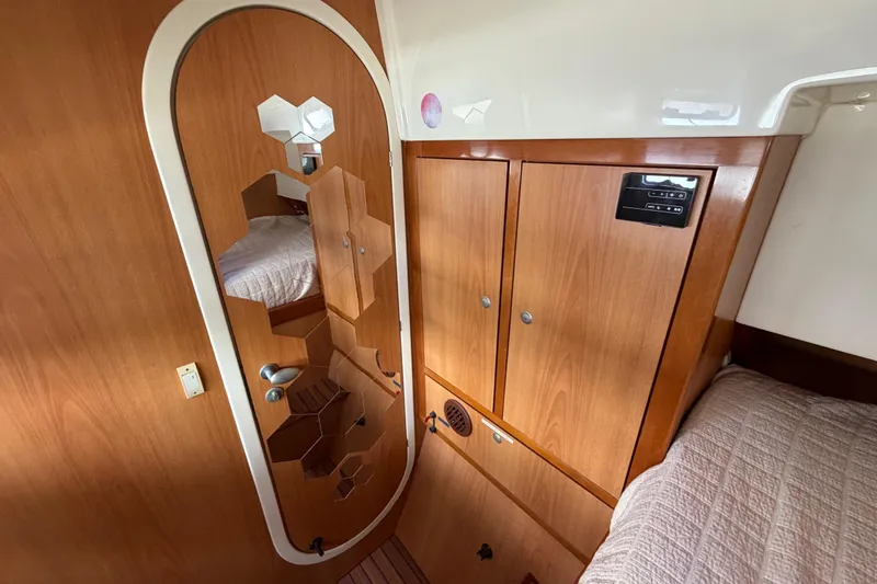 Slide: The Image of Interior of 2007 Dolphin 460 yacht with wooden cabinetry and hexagonal mirror design. - 77