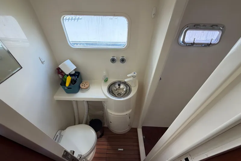 Slide: The Image of Compact bathroom in 2007 Dolphin 460 yacht with sink, toilet, and window. - 79