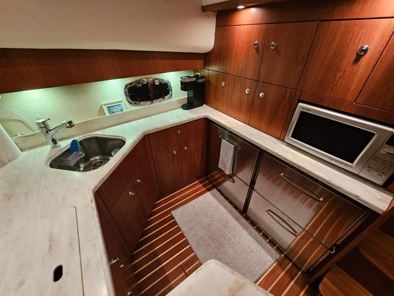 Slide: The Image of 2014 Tiara Yachts 43 Open kitchen area with wooden cabinets. - 16