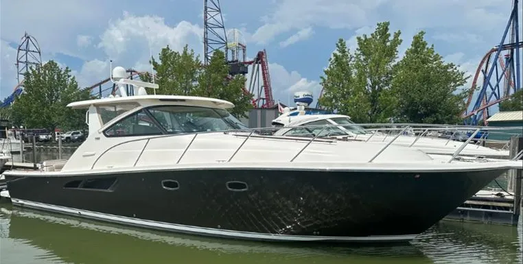 Slide: The Image of 2014 Tiara Yachts 43 Open docked in a marina with trees. - 5