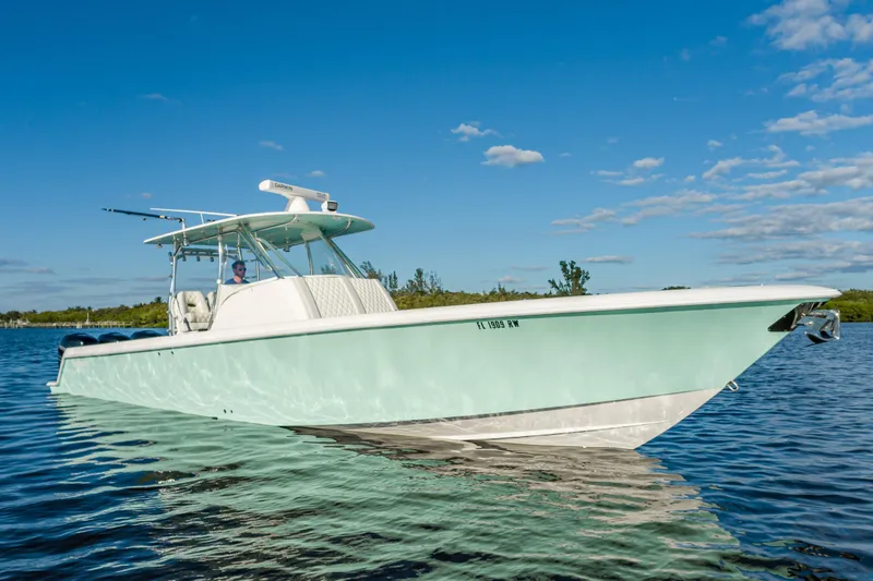 The Image of 2019 Contender 39 Fisharound boat on calm water under clear blue sky. - 0