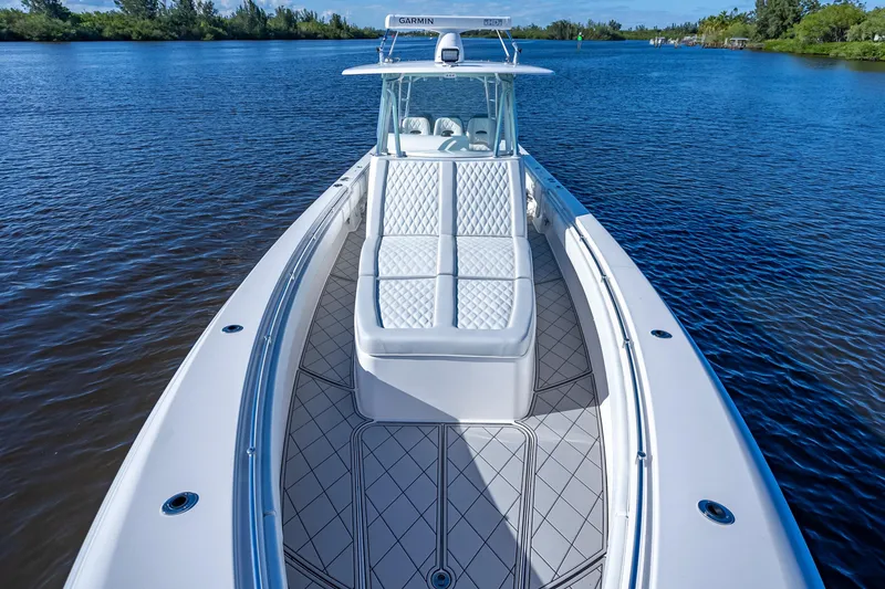 Slide: The Image of 2019 Contender 39 Fisharound boat on calm water, featuring sleek design and spacious deck. - 10