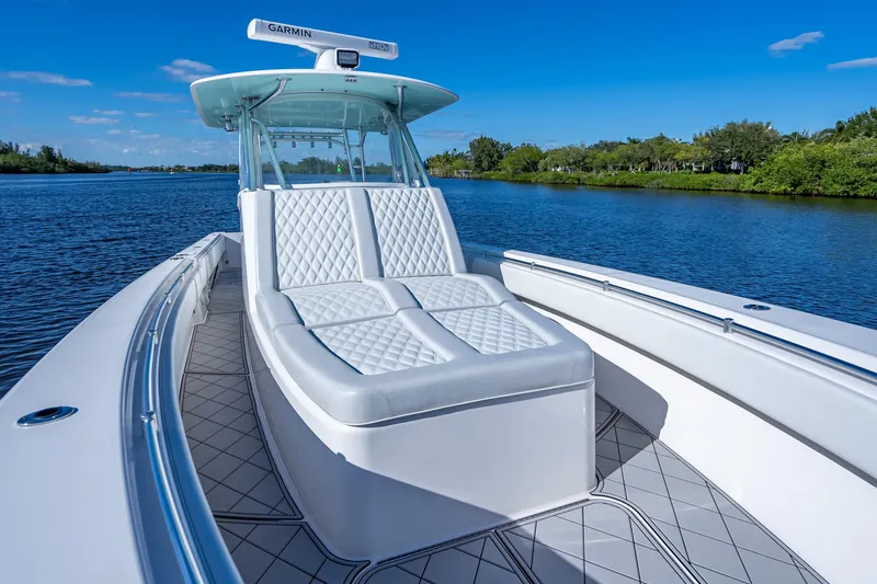 Slide: The Image of 2019 Contender 39 Fisharound boat with cushioned seating on a calm river. - 11