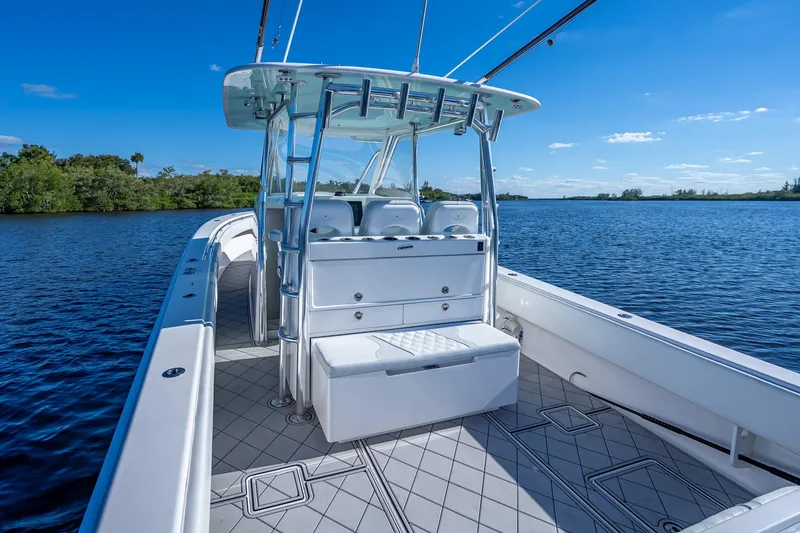 Slide: The Image of 2019 Contender 39 Fisharound boat on calm water, featuring spacious deck and seating. - 12