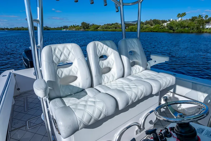 Slide: The Image of 2019 Contender 39 Fisharound boat with luxurious white seating and scenic water backdrop. - 15